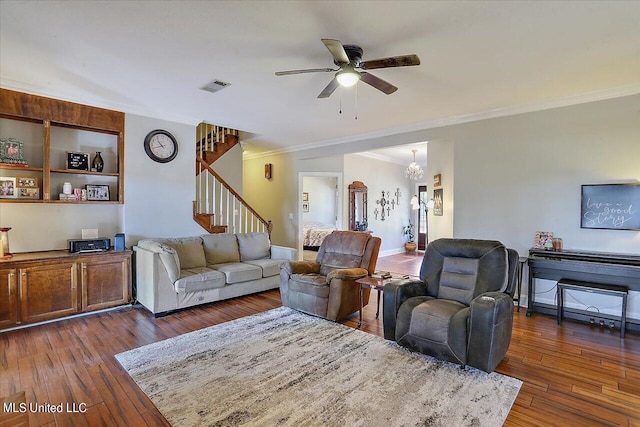 living room with ornamental molding, ceiling fan with notable chandelier, and dark hardwood / wood-style flooring