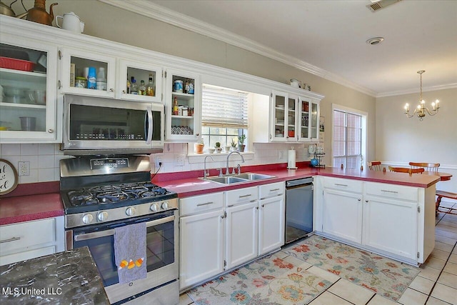 kitchen with appliances with stainless steel finishes, white cabinetry, sink, and pendant lighting