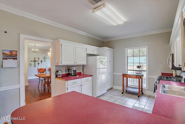 kitchen with light hardwood / wood-style flooring, sink, crown molding, white cabinets, and appliances with stainless steel finishes