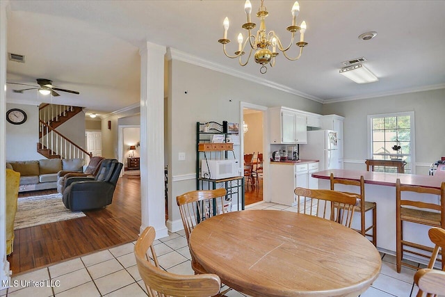 dining room with ornamental molding, ceiling fan with notable chandelier, and light hardwood / wood-style floors