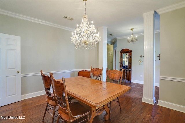 dining room featuring dark wood-type flooring, crown molding, decorative columns, and a chandelier