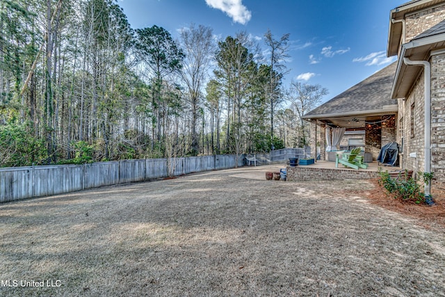 view of yard with a patio area, ceiling fan, and a fenced backyard