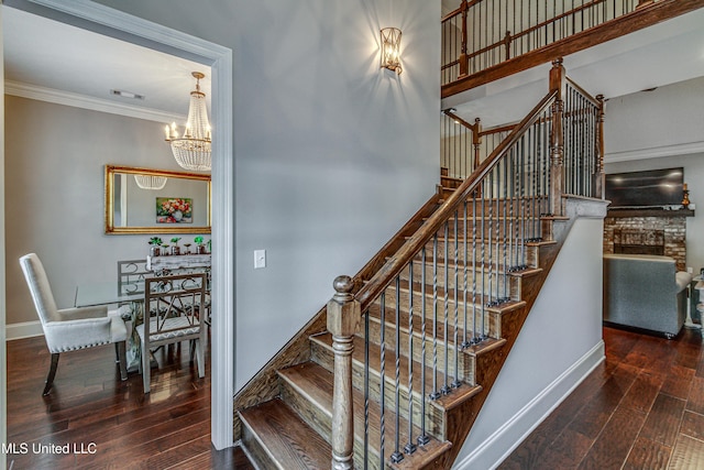 stairs featuring baseboards, a notable chandelier, hardwood / wood-style flooring, and crown molding