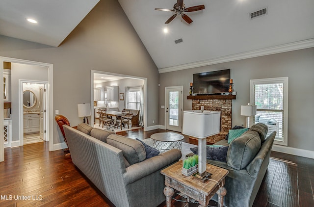 living area featuring dark wood-type flooring, a brick fireplace, visible vents, and baseboards