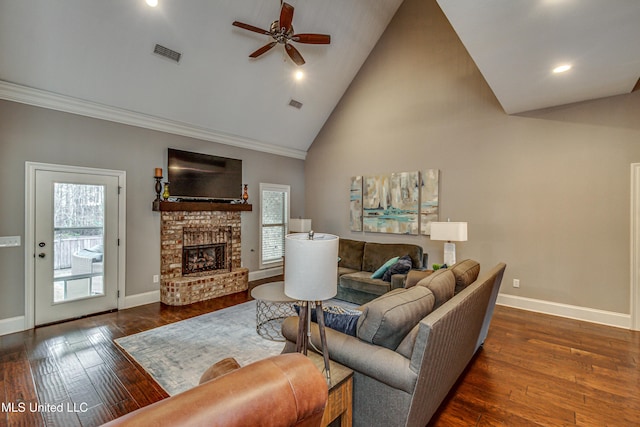 living room with hardwood / wood-style flooring, a brick fireplace, visible vents, and baseboards