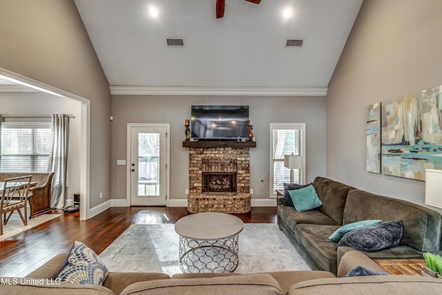 living area featuring baseboards, a fireplace, visible vents, and wood finished floors