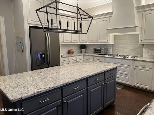 kitchen with ornamental molding, dark wood-style flooring, stainless steel appliances, premium range hood, and backsplash