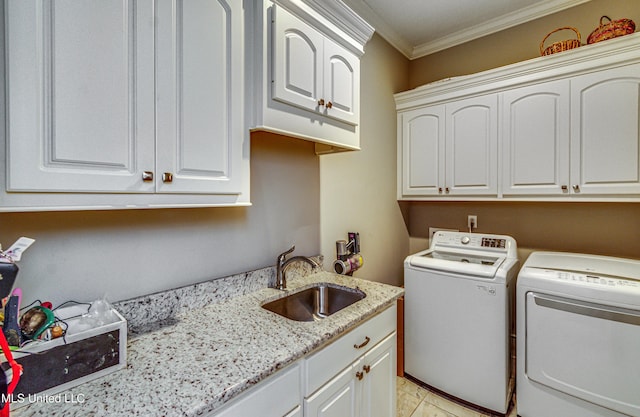 laundry room with cabinet space, ornamental molding, separate washer and dryer, and a sink