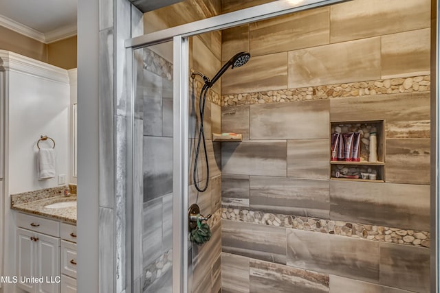 bathroom with crown molding, a tile shower, and vanity