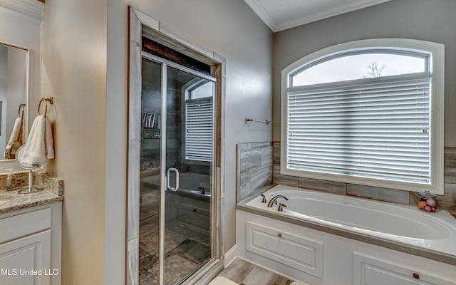 bathroom with a stall shower, ornamental molding, a bath, and vanity