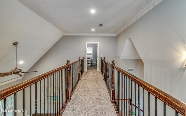 hall featuring carpet, visible vents, crown molding, and an upstairs landing