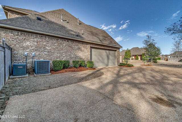 view of property exterior with driveway, brick siding, cooling unit, and roof with shingles