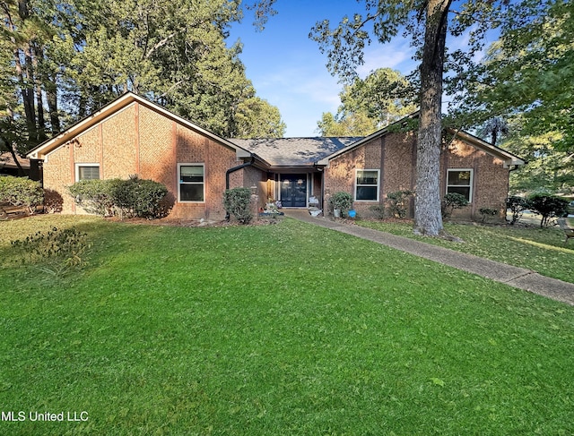 mid-century modern home featuring a front yard and brick siding