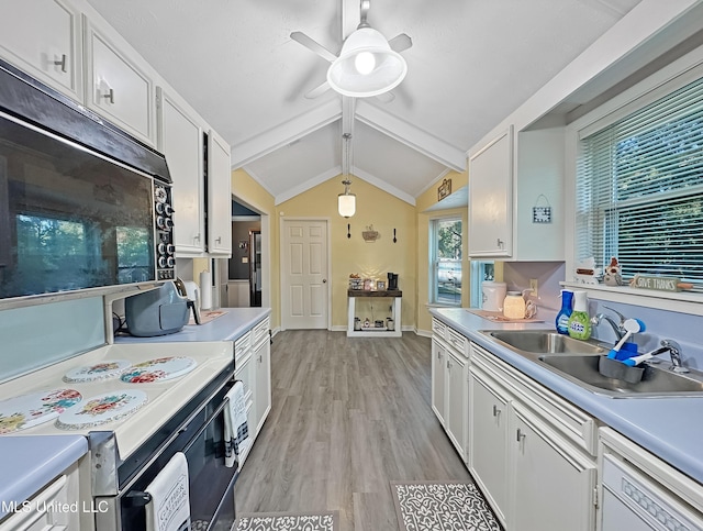 kitchen with vaulted ceiling with beams, black microwave, white cabinets, and dishwasher