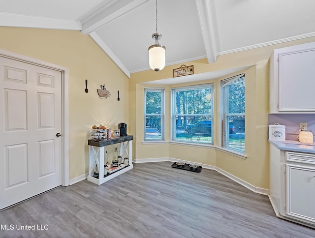 dining area with vaulted ceiling with beams, light wood-style floors, and baseboards