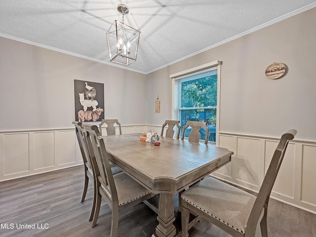 dining room featuring a textured ceiling, wood finished floors, and crown molding