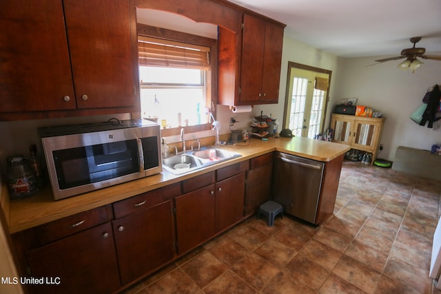 kitchen featuring kitchen peninsula, ceiling fan, appliances with stainless steel finishes, french doors, and sink