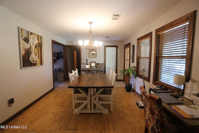 dining room featuring light hardwood / wood-style flooring and a chandelier