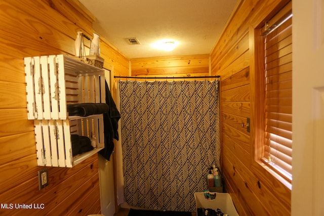 bathroom with wooden walls and a textured ceiling