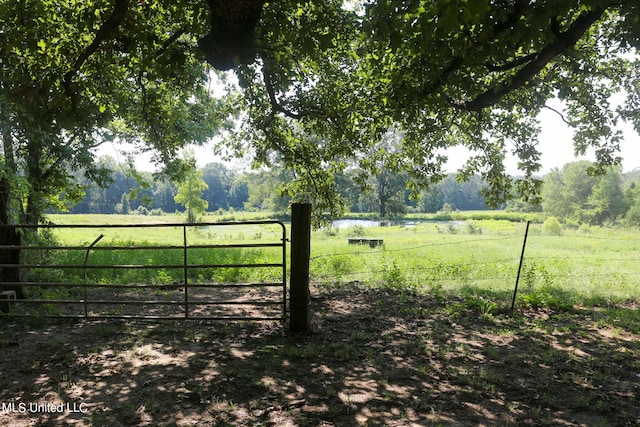 view of gate featuring a water view and a rural view