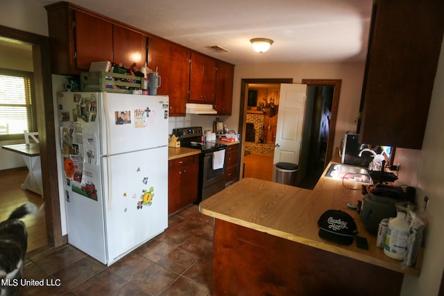 kitchen featuring kitchen peninsula, white fridge, sink, and black electric range