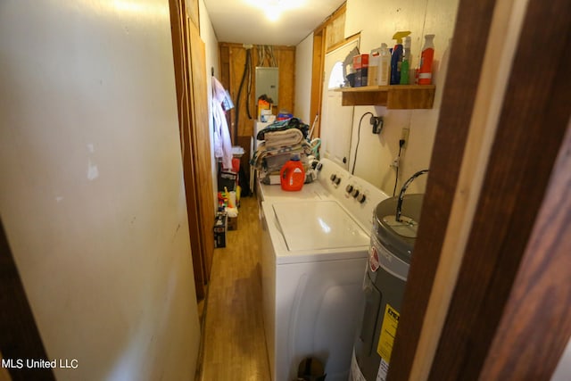 laundry area featuring electric panel, water heater, wood-type flooring, and separate washer and dryer