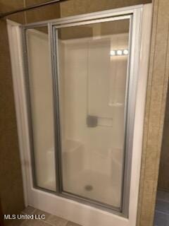 bathroom with tile patterned flooring and a stall shower