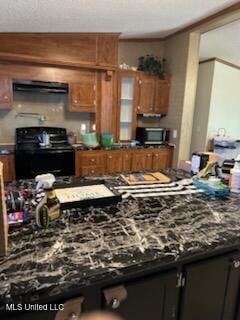 kitchen featuring brown cabinets, ventilation hood, dark countertops, glass insert cabinets, and black range with electric cooktop