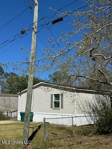 view of side of property with a lawn and fence