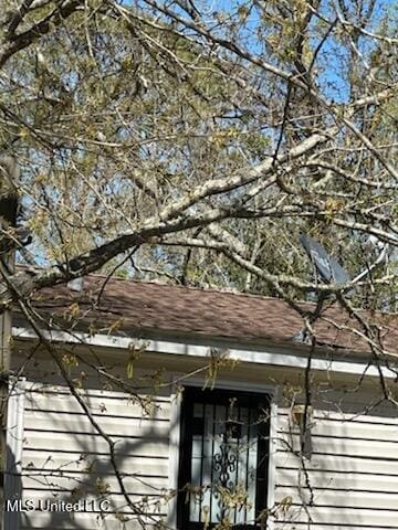 exterior details with roof with shingles