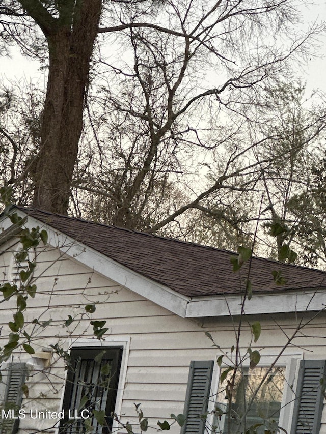 exterior details featuring roof with shingles