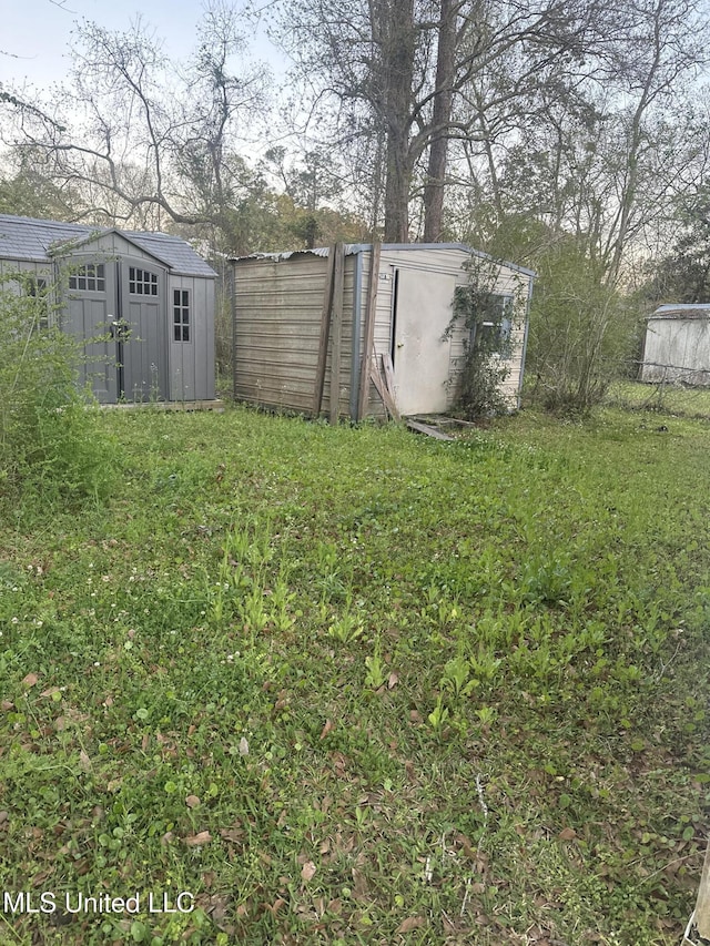 view of yard featuring fence, an outdoor structure, and a storage shed