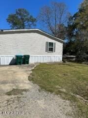 view of side of home with a yard