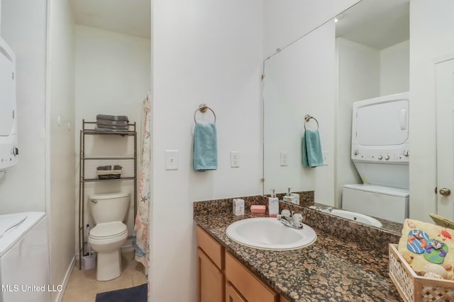 full bath with tile patterned floors, stacked washer and dryer, vanity, and toilet