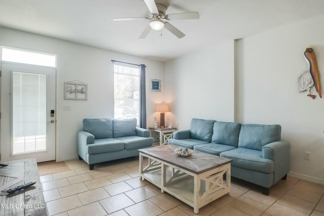 living room featuring light tile patterned floors, a ceiling fan, and baseboards