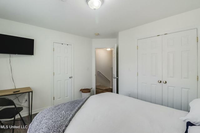 bedroom featuring wood finished floors, baseboards, and a closet