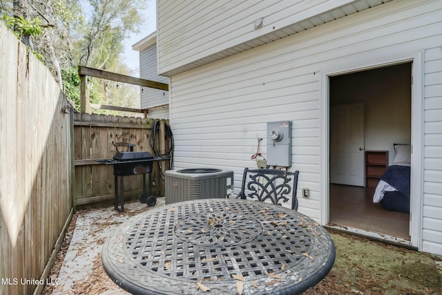 view of patio / terrace with outdoor dining area, central AC unit, and fence