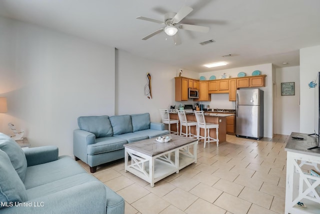 living room with light tile patterned floors, visible vents, and ceiling fan