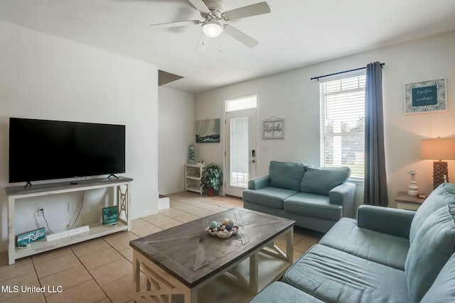 living room featuring light tile patterned flooring, a ceiling fan, and baseboards