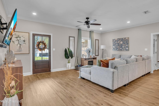 living room featuring crown molding, light wood-type flooring, and ceiling fan