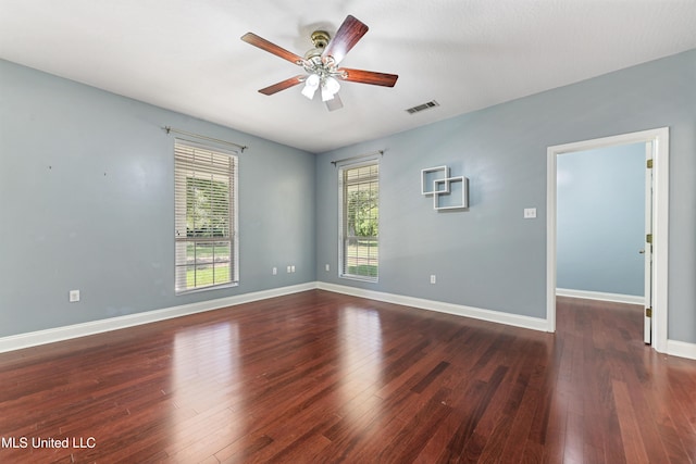 empty room with dark wood-type flooring and ceiling fan