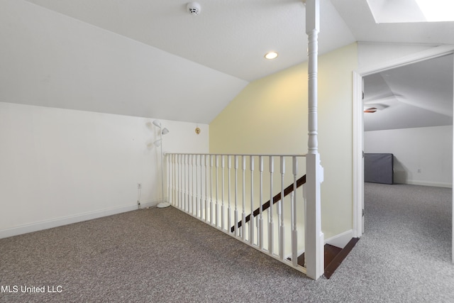 additional living space featuring vaulted ceiling with skylight and carpet