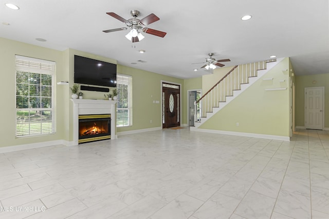 unfurnished living room with ceiling fan