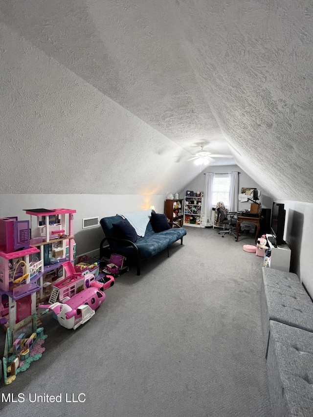 recreation room featuring vaulted ceiling, carpet, and a textured ceiling