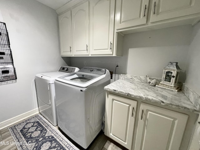 laundry area featuring cabinets, hardwood / wood-style floors, and washer and dryer