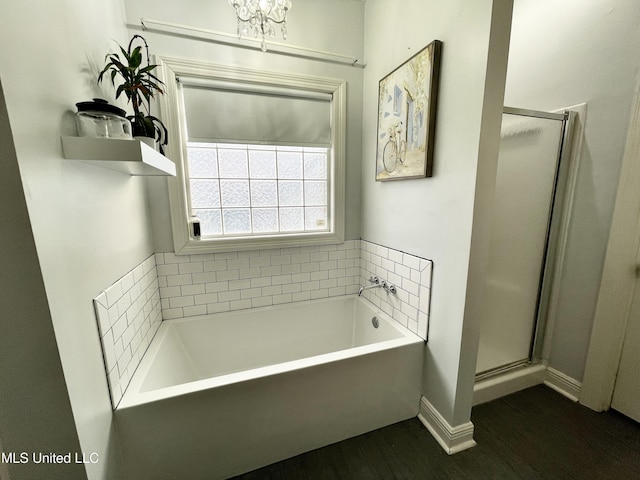 bathroom with wood-type flooring and shower with separate bathtub