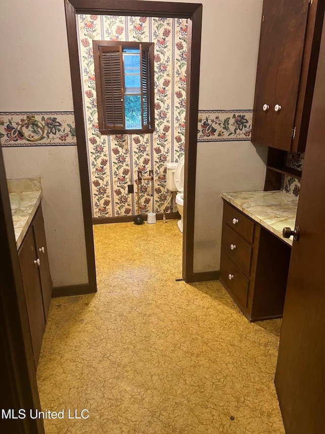 bathroom with tile patterned floors, toilet, vanity, and baseboards