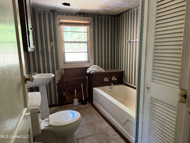 full bathroom with wallpapered walls, a bath, and toilet