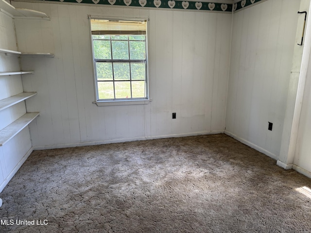 carpeted spare room featuring baseboards