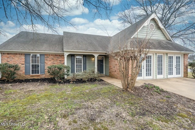 view of front of home featuring roof with shingles and brick siding